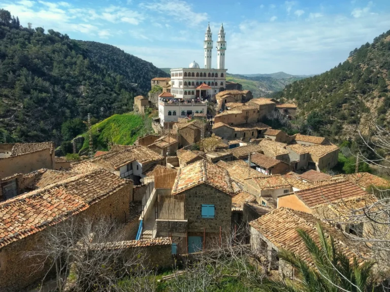A village or town nestled in a valley with traditional buildings and green hills.