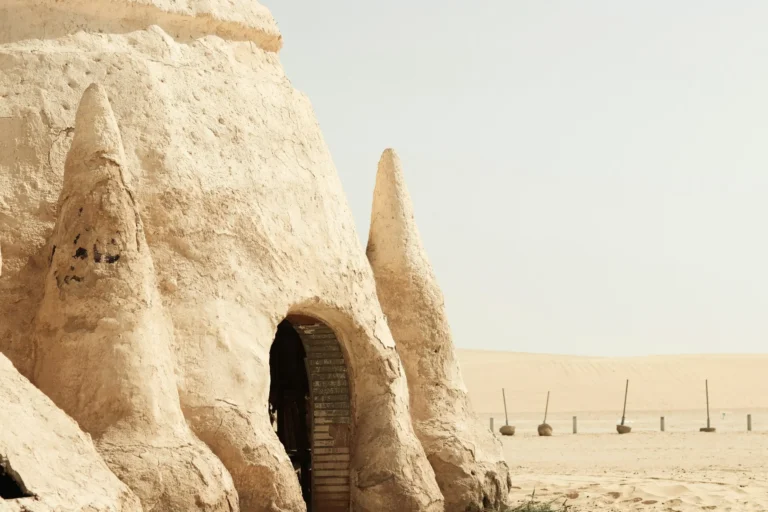 A unique building or dwelling carved into or built from rock or sand, possibly a cave dwelling.