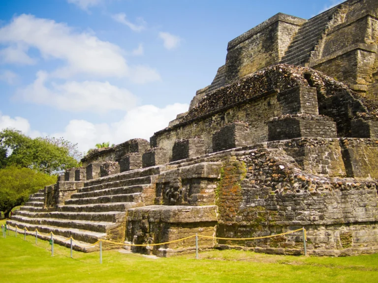 An ancient Mayan pyramid or temple under a blue sky.