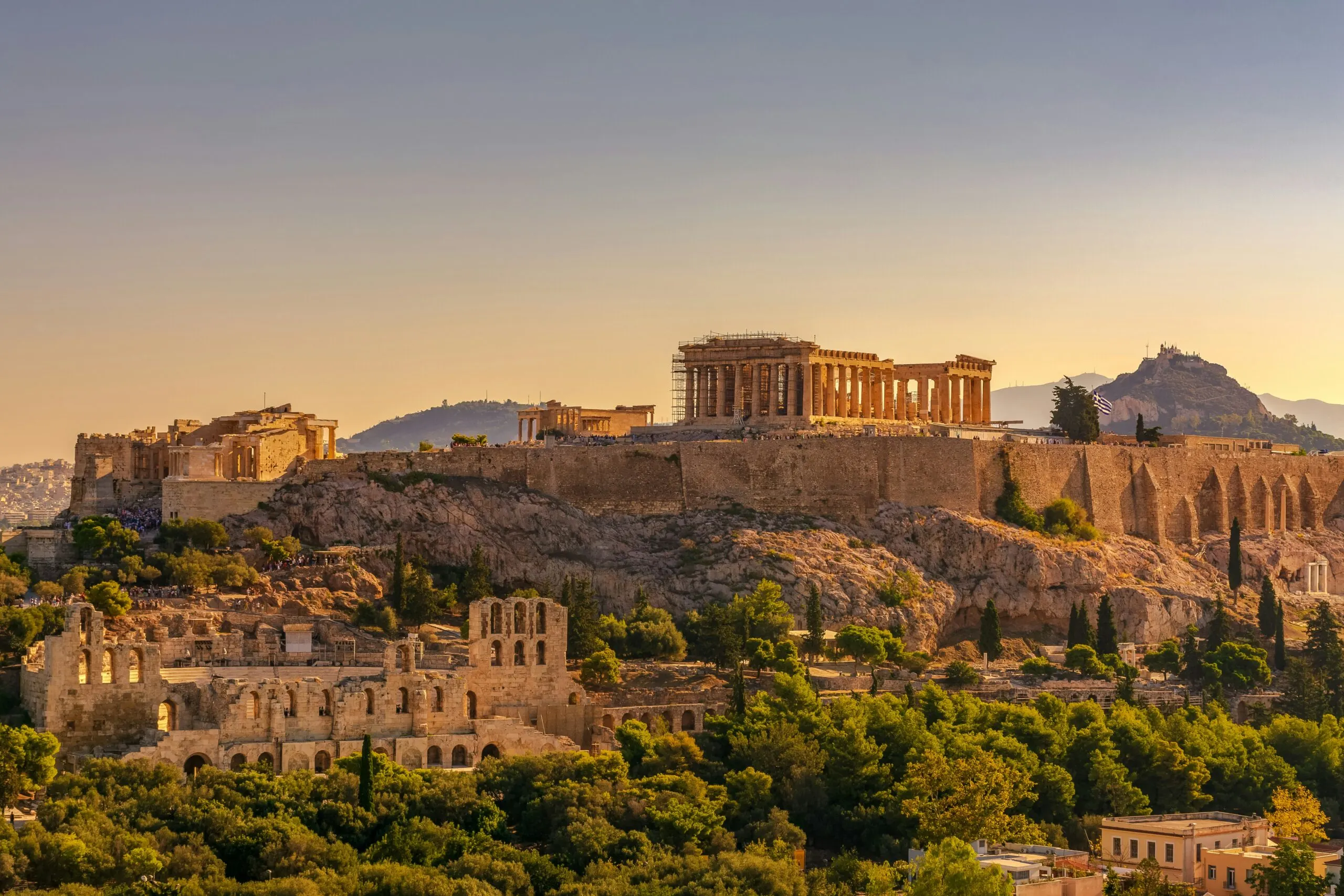 The ancient Acropolis of Athens, Greece, with the Parthenon, bathed in warm sunlight.