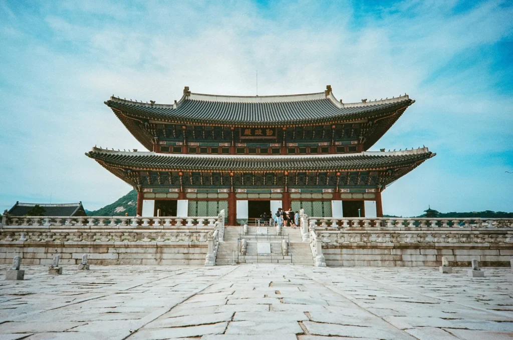 The Gyeongbokgung Palace in Seoul, South Korea, showcasing its grand architectural style under a blue sky.