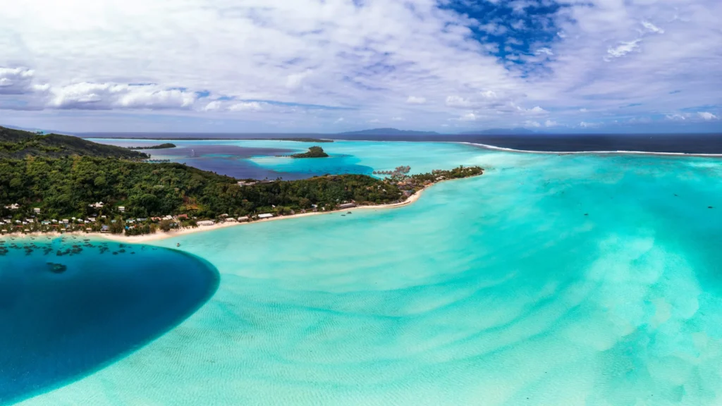 An aerial view of a tropical lagoon with clear turquoise water and lush green islands.