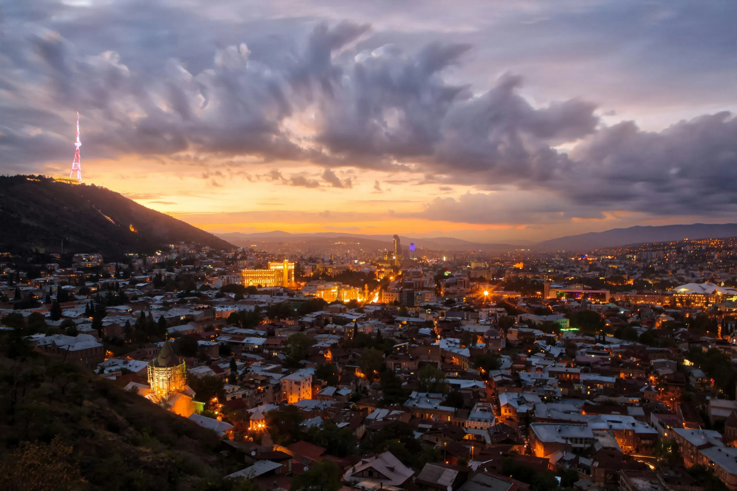 Town nestled in mountains at sunset