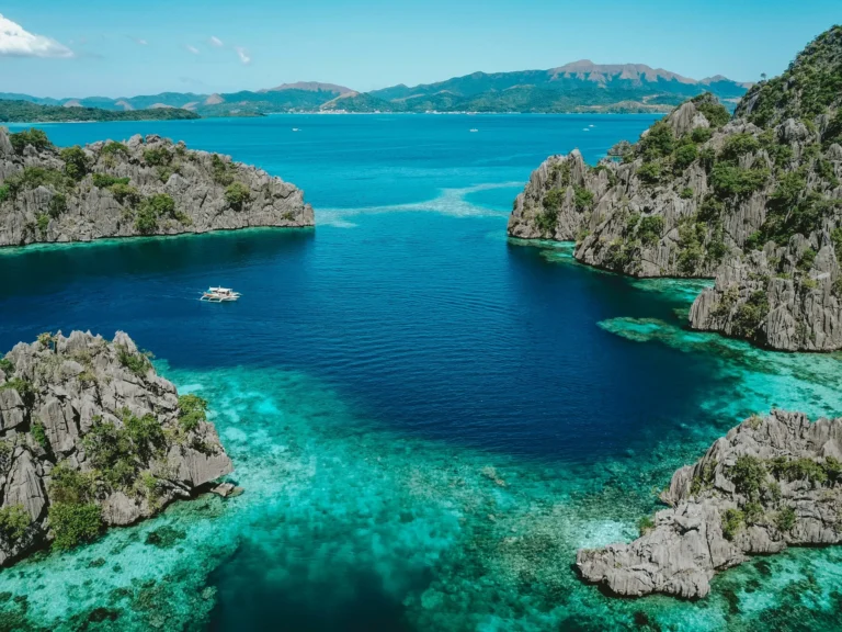 A stunning lagoon with towering limestone cliffs and vibrant blue-green water, a popular spot for snorkeling and swimming.