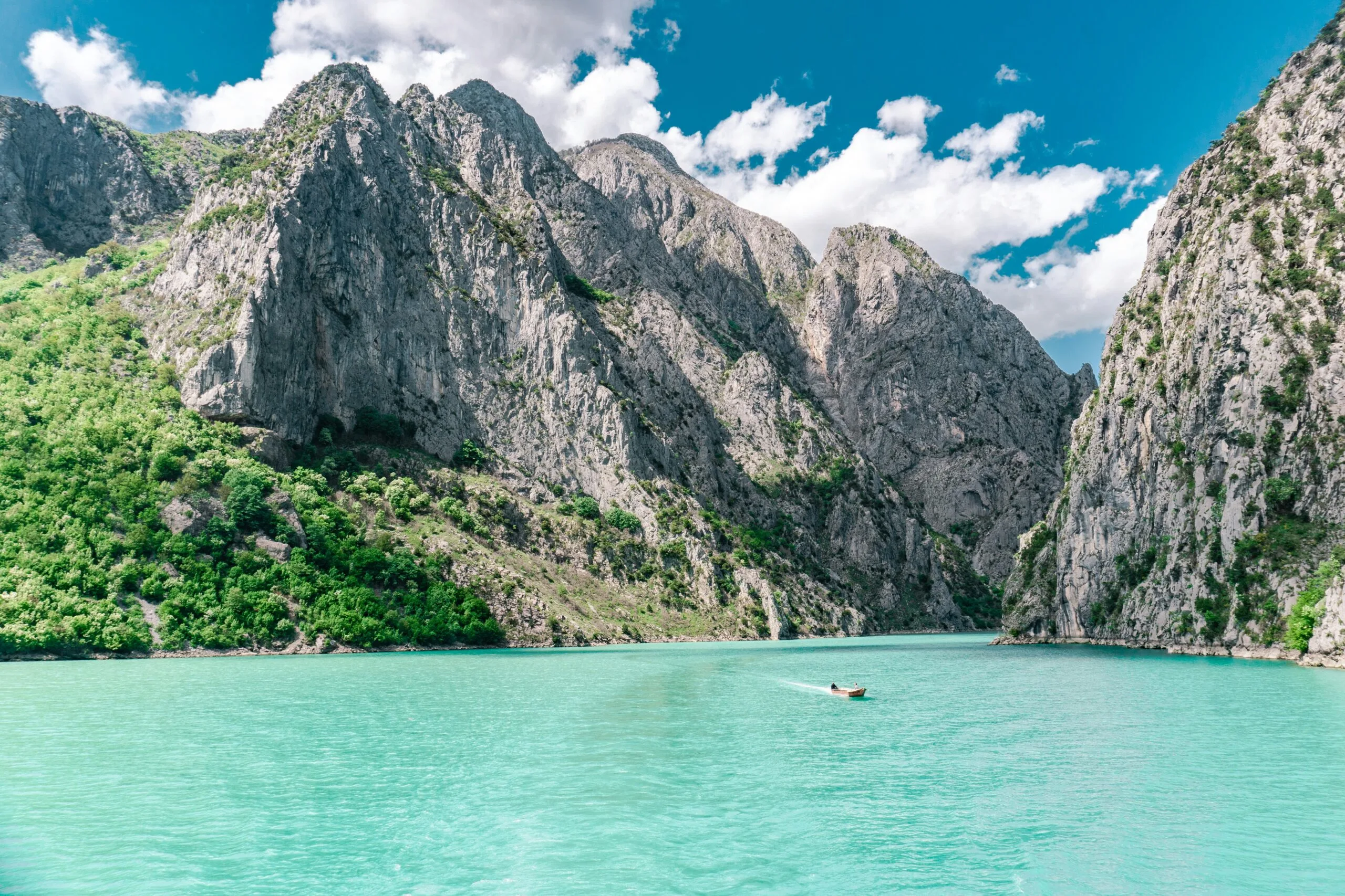 A serene lake with vibrant turquoise water nestled between rugged mountains.