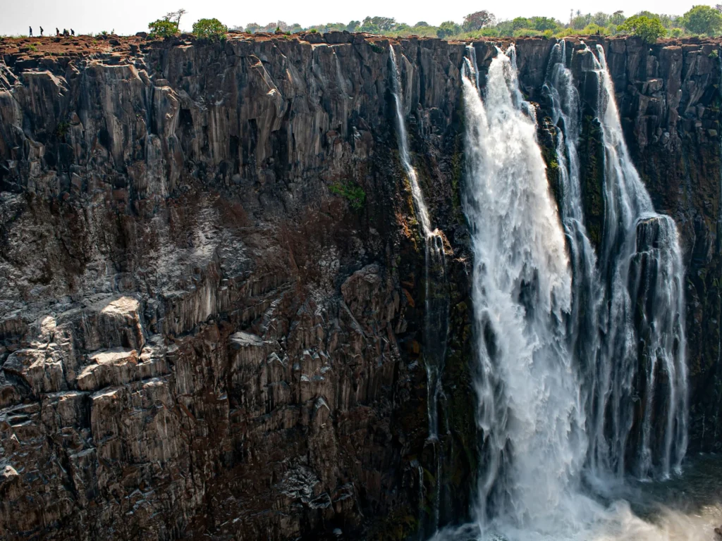 A large waterfall plunges down a rocky cliff face.