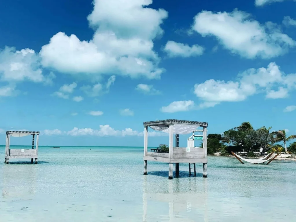 A shallow, clear blue lagoon with white cabanas and clear skies.
