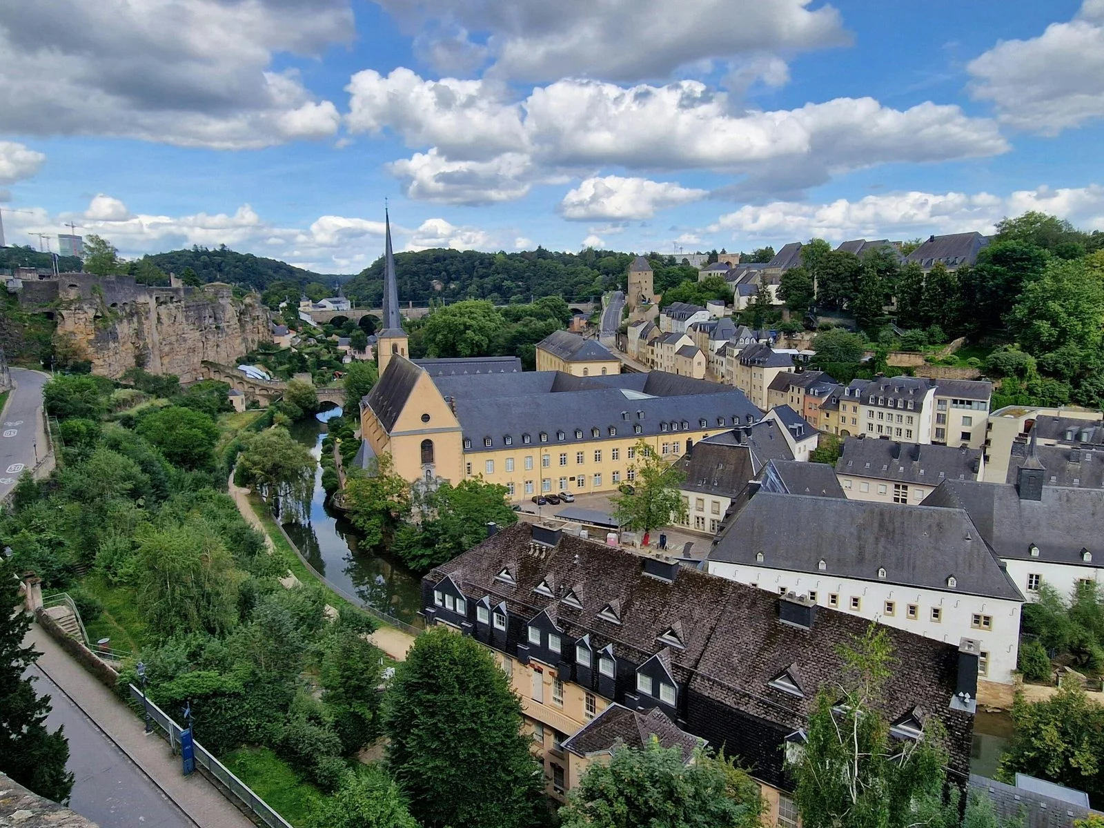 A panoramic view of a town with a river running through it and buildings clustered on the hillsides.