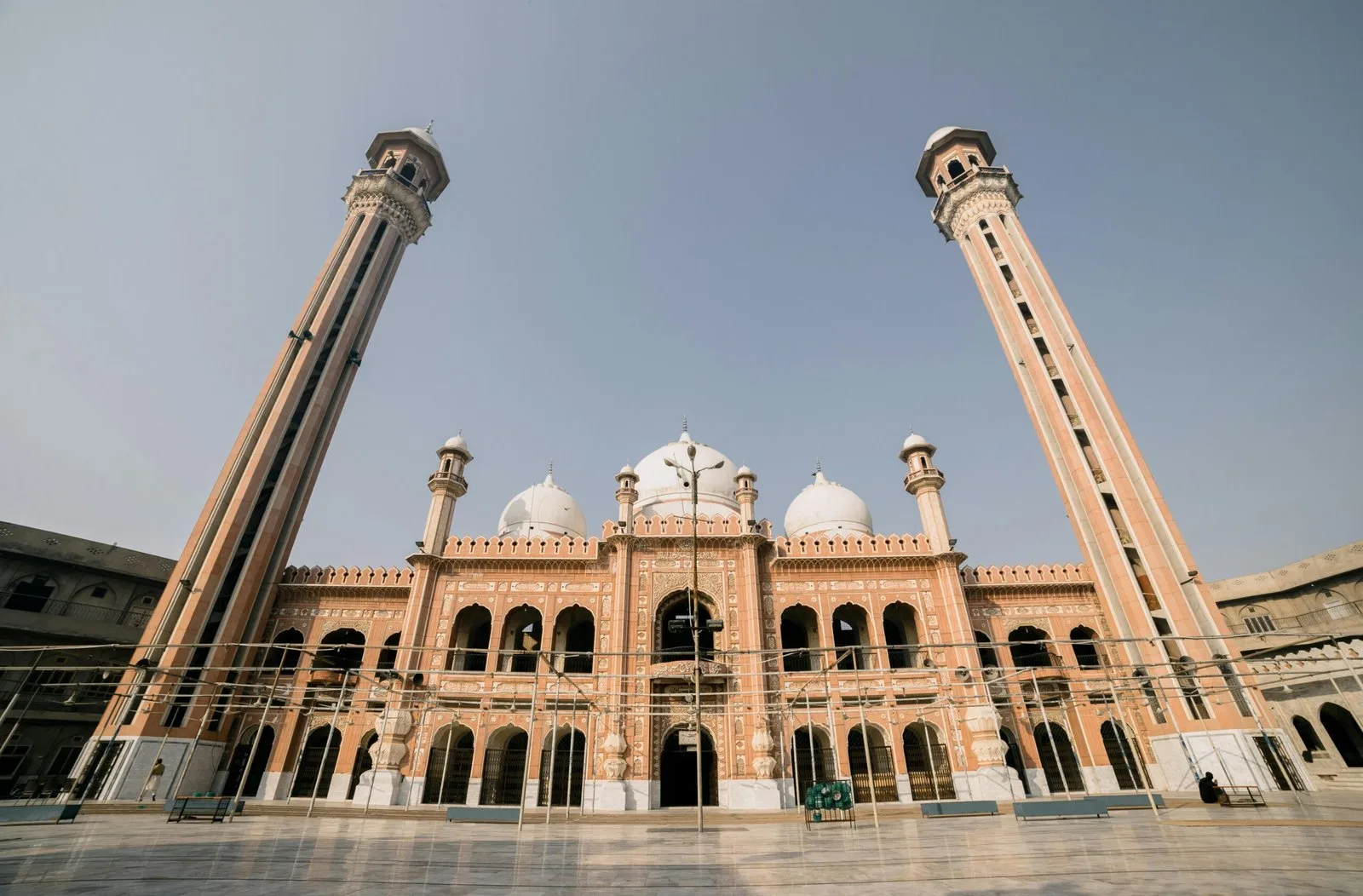A low-angle shot of a large mosque with two minarets and a central dome.