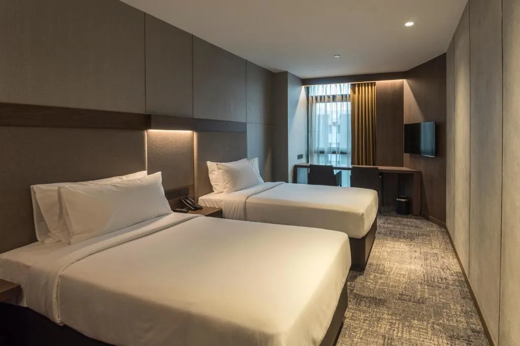 Minimalist hotel room with two beds, desk and soft lighting, perfect quiet off-season travel retreat