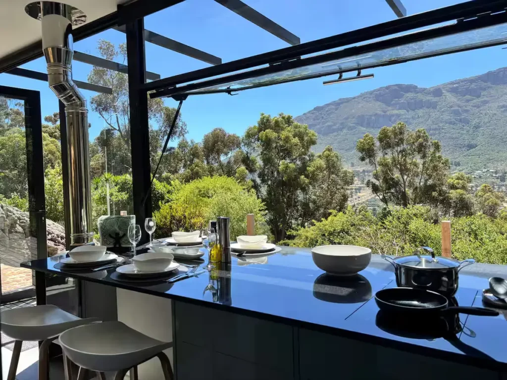 Modern vacation kitchen island set with tableware overlooking mountain view in off-season calm.