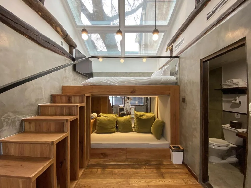 Cozy loft bedroom with skylight, rustic wood design and plush seating in a quiet off-season boutique hotel retreat