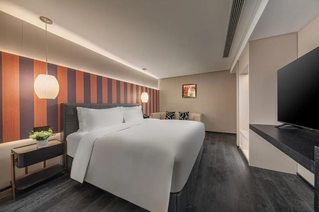 Empty modern hotel bedroom with king bed, warm lighting and minimalist decor in a quiet off-season travel setting