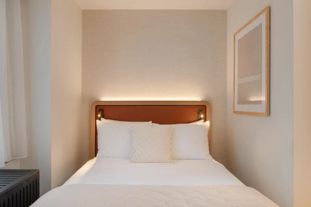 Cozy boutique hotel room with crisp white bedding and warm ambient lighting, perfect for a quiet off-season getaway.