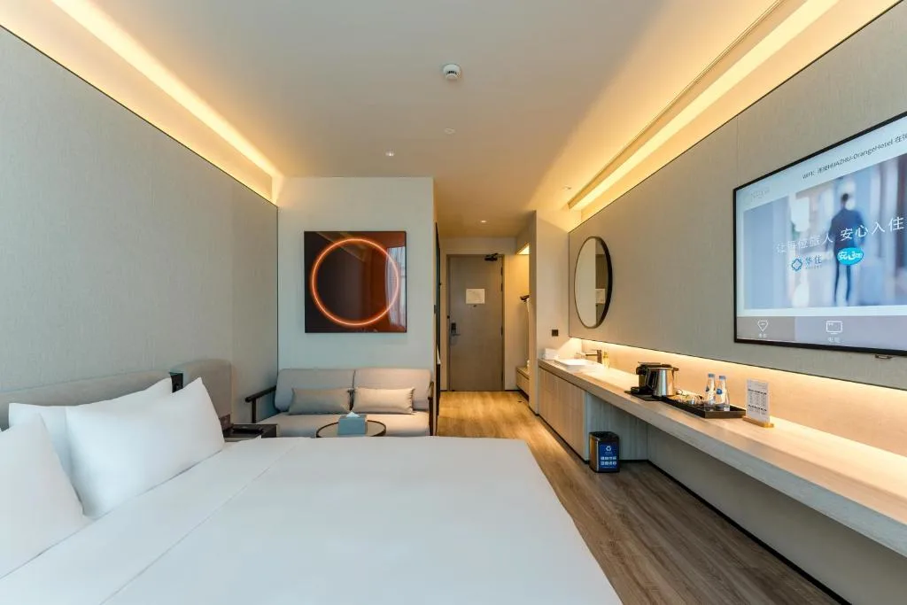 Spacious modern hotel room interior with king bed, lounge sofa and warm lighting, quiet off-season travel retreat