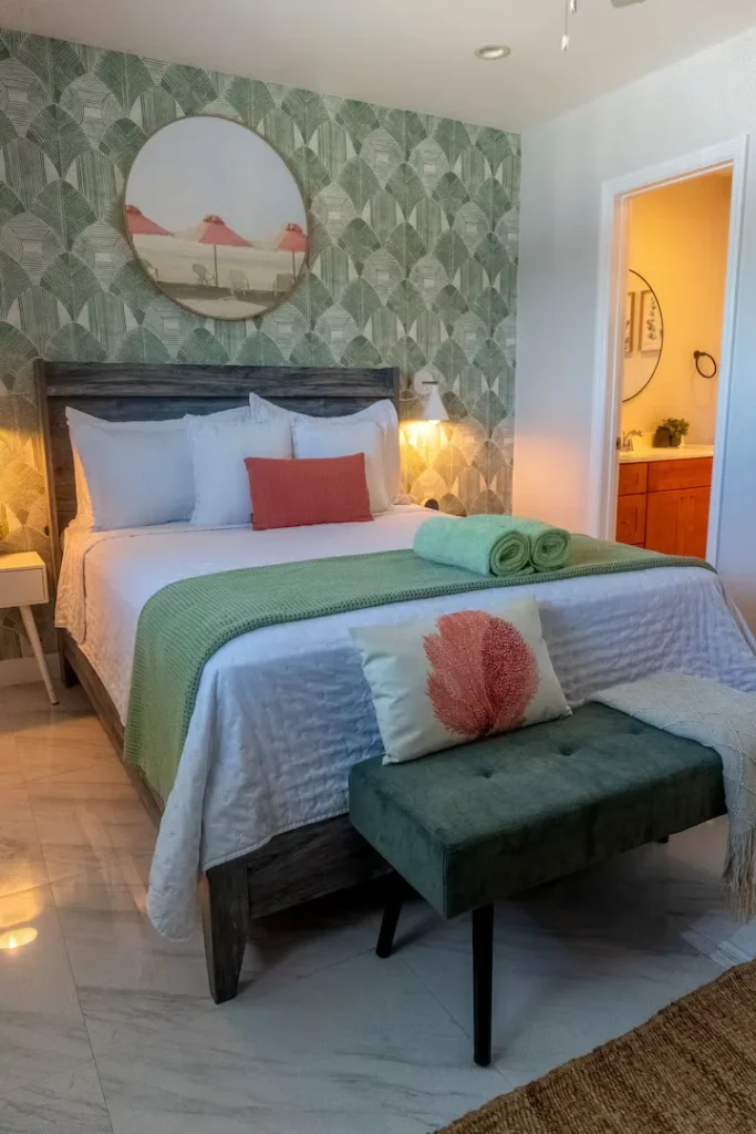 Cozy off-season beachside suite with neatly made bed, soft lighting and tropical decor for a tranquil, uncrowded getaway.
