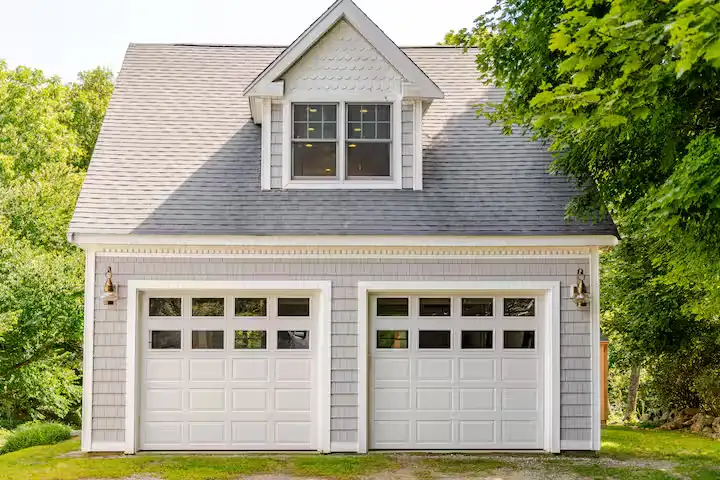 Quiet off-season cottage garage hidden among summer greenery, perfect for secluded travel retreats.