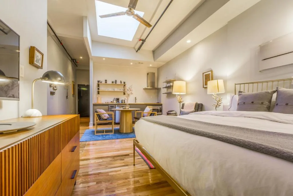 Cozy boutique hotel suite with king bed, skylight and wood floors, softly lit off-season retreat for peaceful travel stays