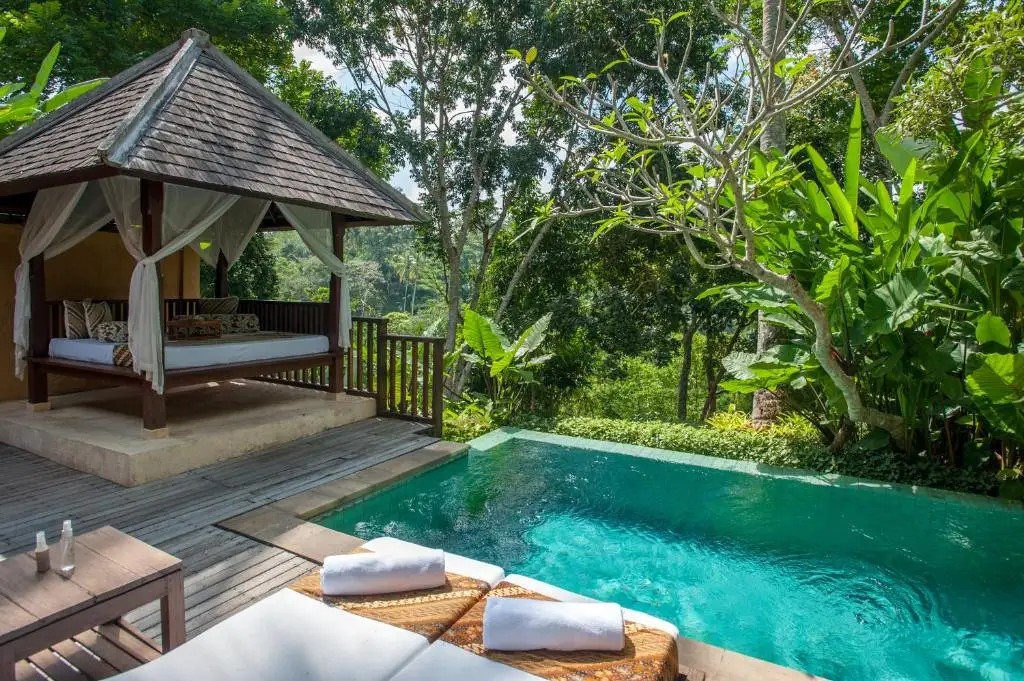 Secluded tropical villa with empty poolside gazebo overlooking lush jungle, off-season serenity and hidden travel escape.