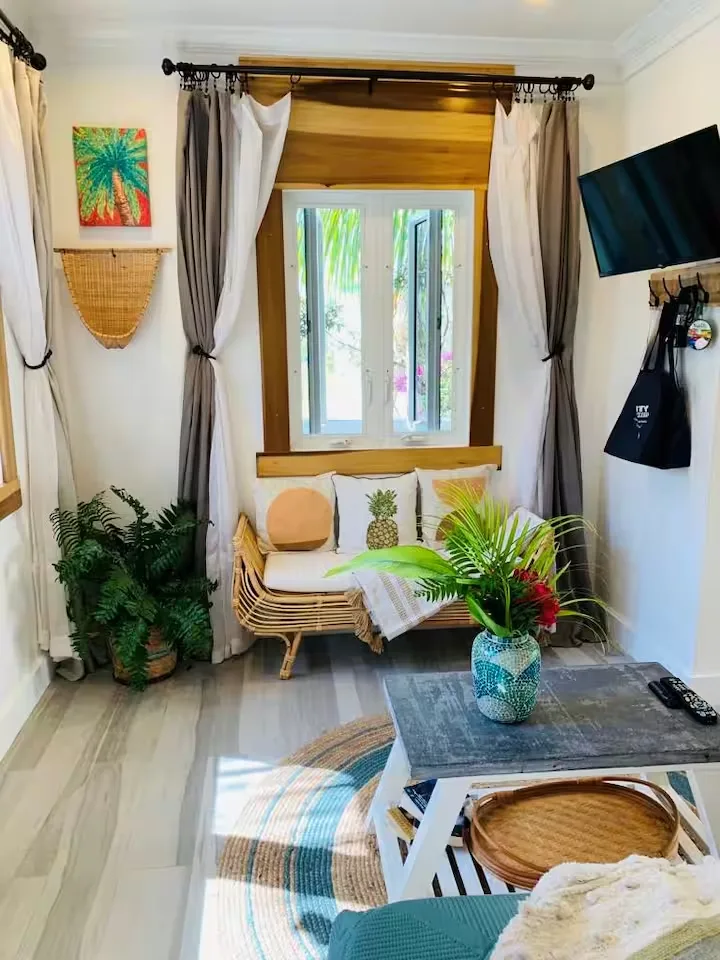 Quiet tropical off-season suite with rattan sofa, leafy green decor and natural light for a cozy travel retreat