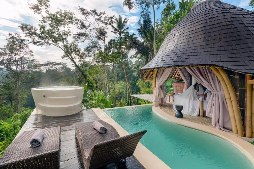 Luxury jungle retreat with infinity pool, steaming hot tub and loungers amid lush greenery in off-season tranquility