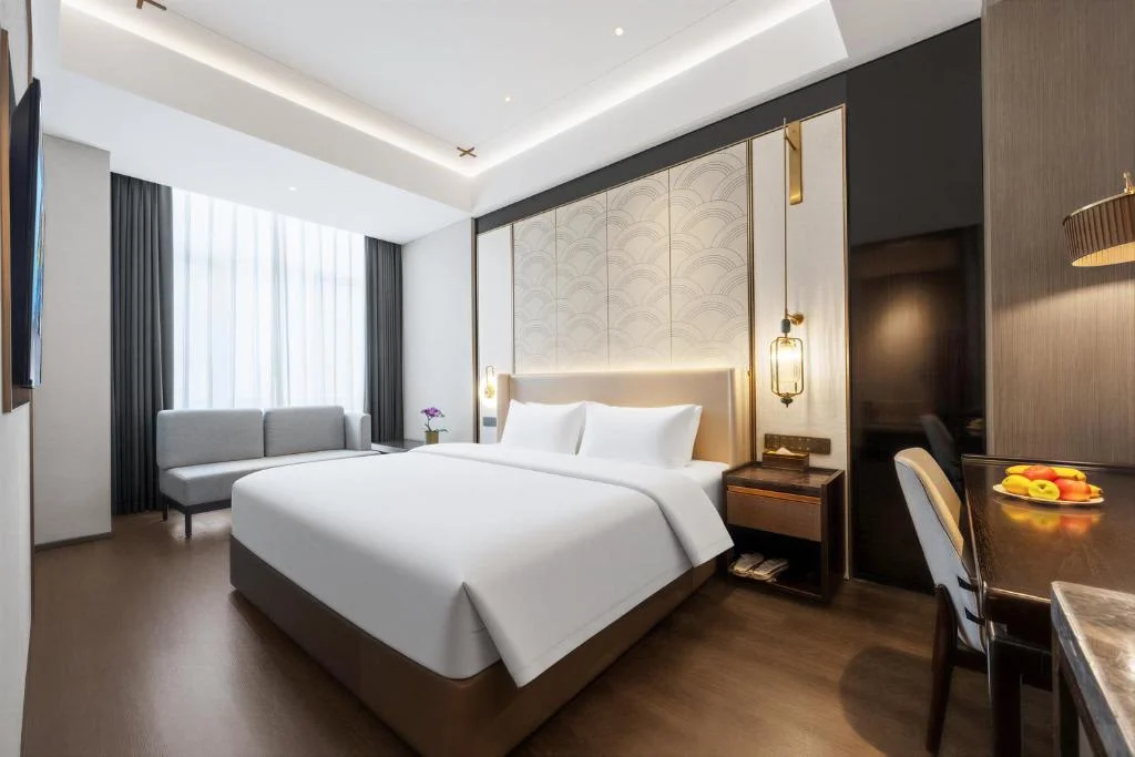Spacious modern hotel room with king bed, wooden floors and seating area in a serene off-season quiet atmosphere