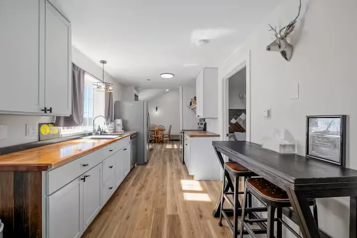 Sunlit modern kitchen and dining area in an off-season vacation cabin, perfect for a quiet travel retreat.