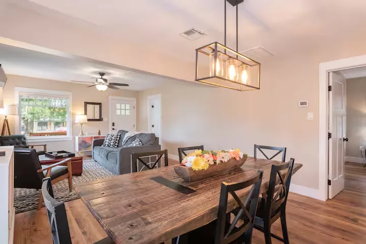 Cozy quiet off-season vacation rental interior with rustic wooden dining table and bright living room seating.