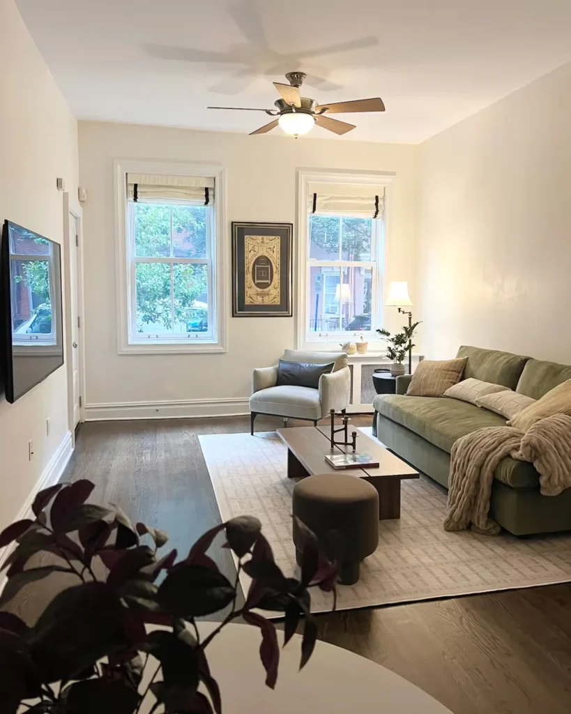 Quiet off-season city apartment living room with minimalist decor, plush sofa and empty street view.