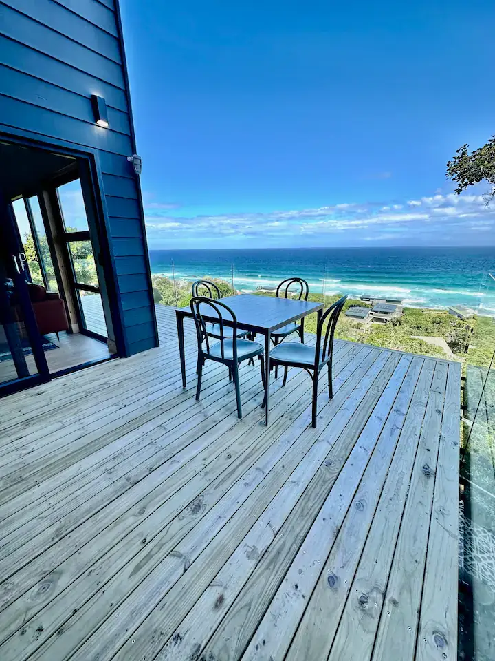 Off-season beach deck with empty table and chairs and panoramic ocean view on quiet coastal retreat