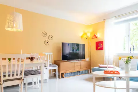 Cozy travel rental living room with yellow walls, wood furniture and off-season calm ambiance.