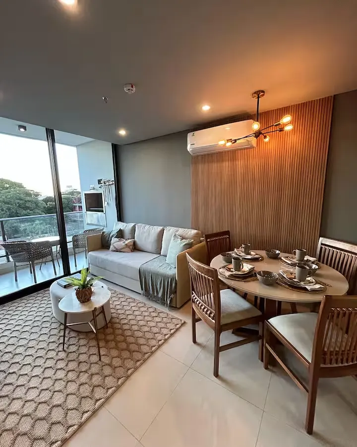 Cozy modern apartment living and dining area for a quiet off-season getaway with sofa, dining table and balcony view