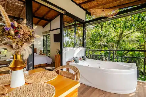 Secluded jungle bungalow retreat with outdoor soaking tub, sunlit rattan furnishings and lush green canopy off-season calm.