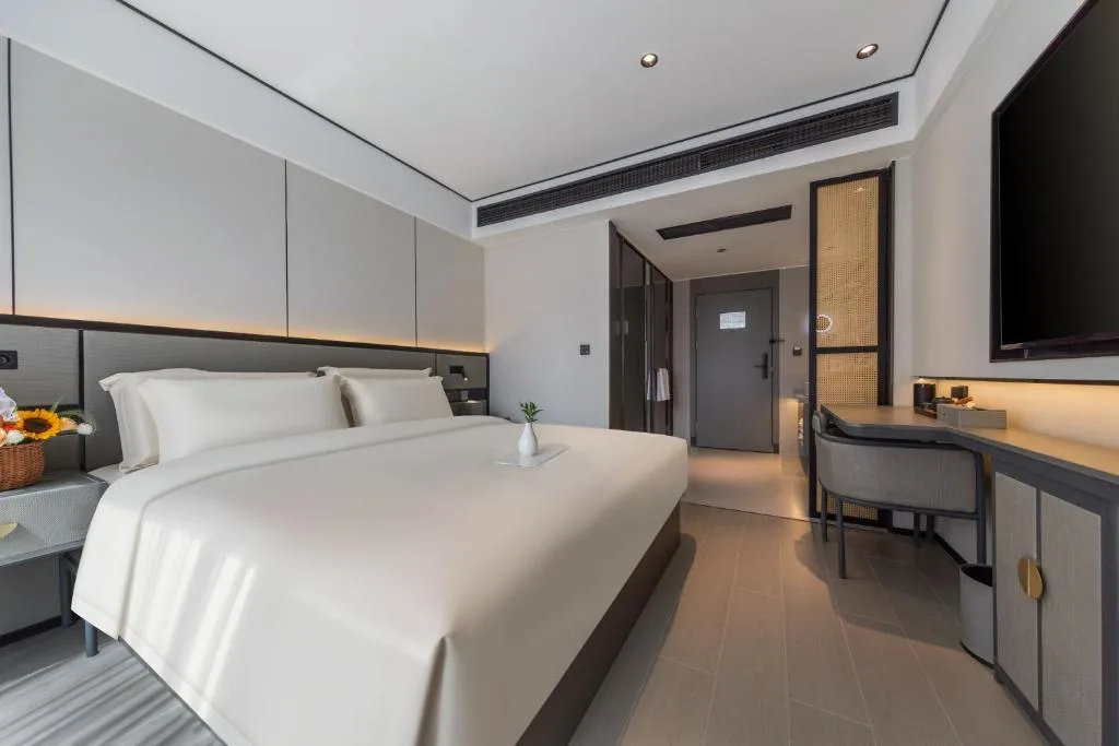 Empty modern hotel room with king bed, minimalist decor and soft lighting, offering quiet off-season travel retreat