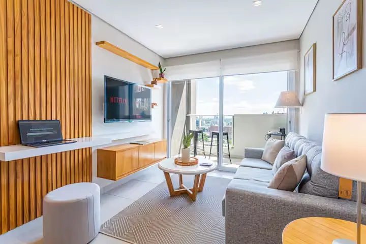 Bright, modern vacation apartment living room with balcony city view, serene off-season getaway in a quiet travel rental.
