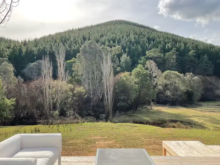 Patio seating overlooking a quiet, off-season forested hillside in soft autumn light, ideal for peaceful countryside retreats