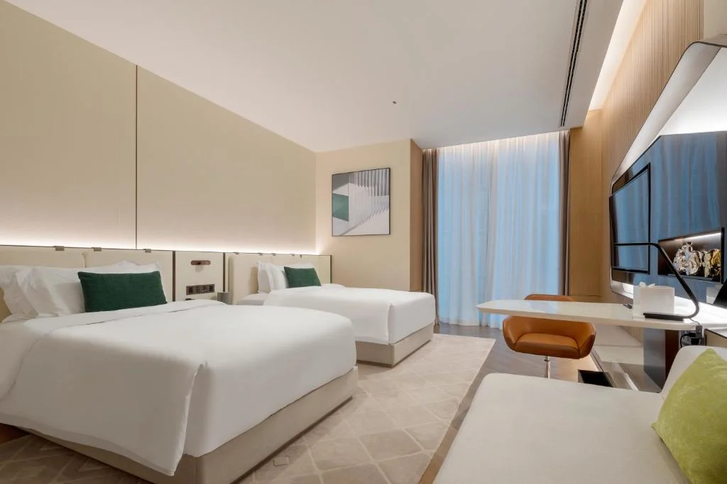 Empty modern hotel room with two double beds, soft lighting and minimal decor, perfect off-season travel retreat.