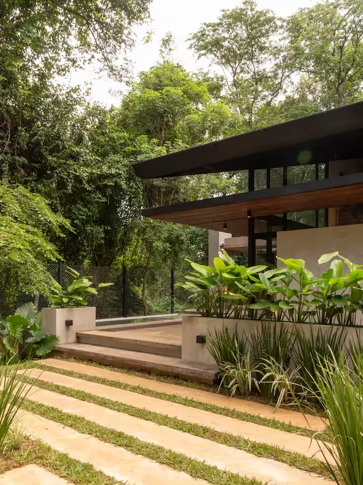 Modern tropical forest villa with empty wooden deck and lush greenery, a serene off-season travel retreat.