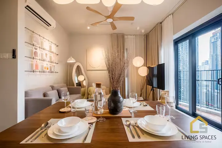 Cozy off-season urban vacation rental interior with modern dining setup, living area and city skyline view from balcony