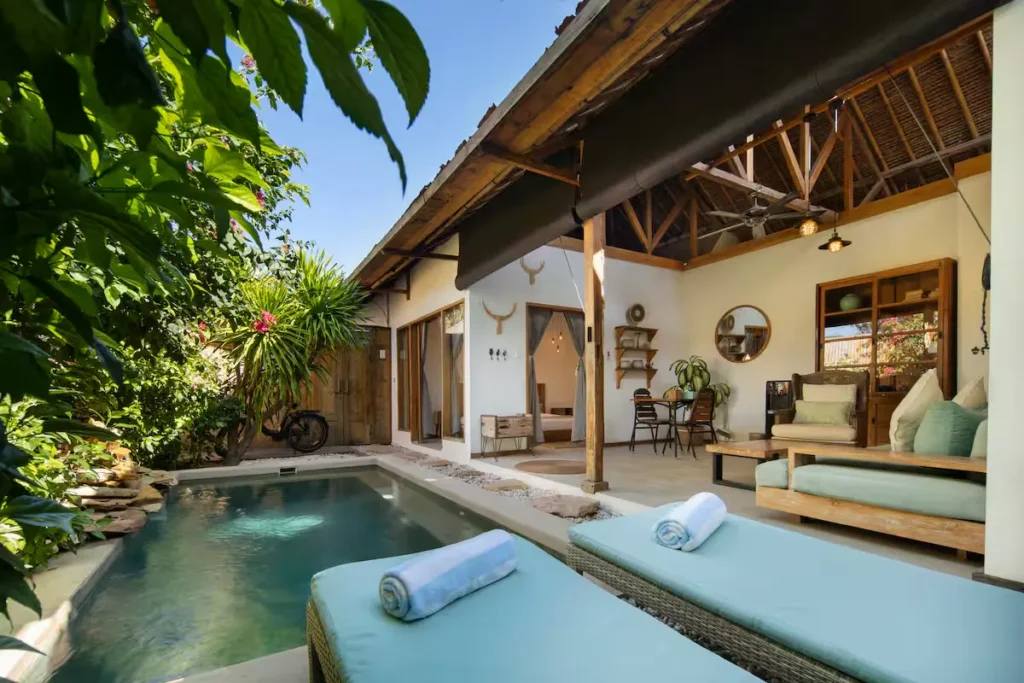Secluded tropical villa with private pool, sun loungers and lush greenery, perfect for off-season travel retreat.