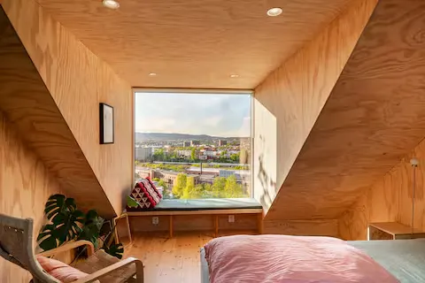 Minimalist wooden loft with river view, cozy off-season city retreat bathed in soft natural light, perfect for quiet getaways