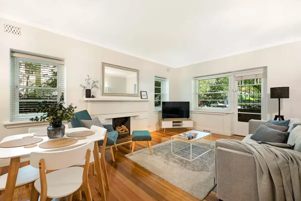 Bright, modern vacation rental living room with hardwood floors and dining area, serene and cozy off-season retreat