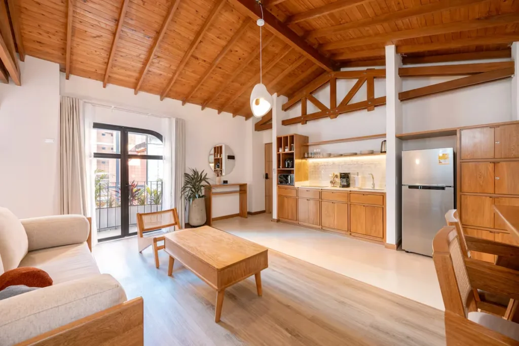 modern wooden loft apartment living space with kitchenette and balcony, off-season vacation rental serenity
