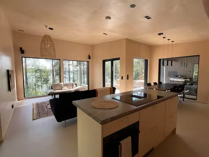 Minimalist lakeside cabin interior with panoramic forest views, serene off-season ambiance perfect for a quiet nature retreat