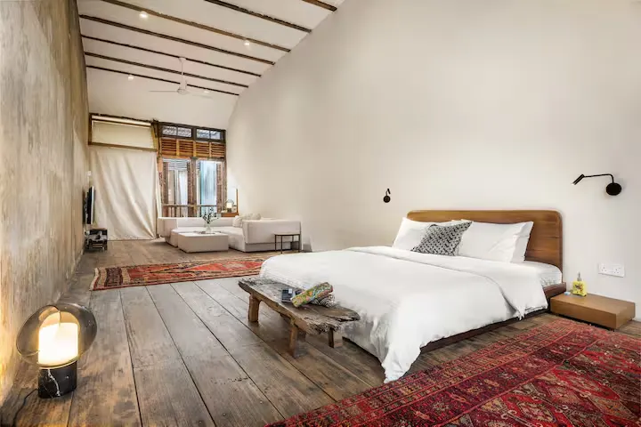 Spacious off-season boutique hotel suite with minimalist design, exposed beams, wooden floors and natural light