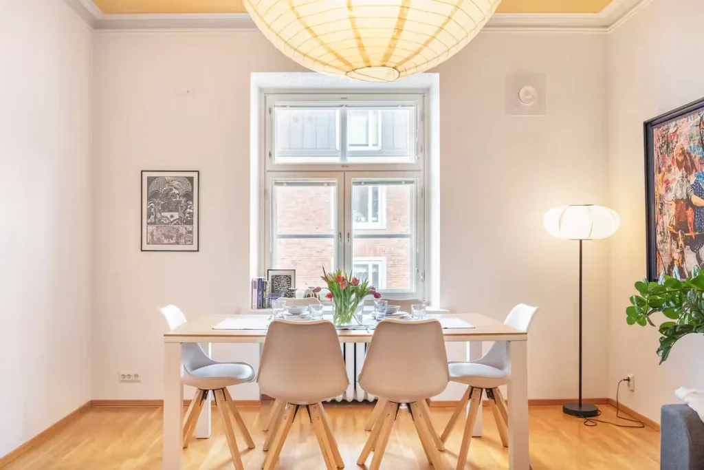 Cozy off-season vacation rental dining area with tulip centerpiece, minimalist modern decor and soft natural light.