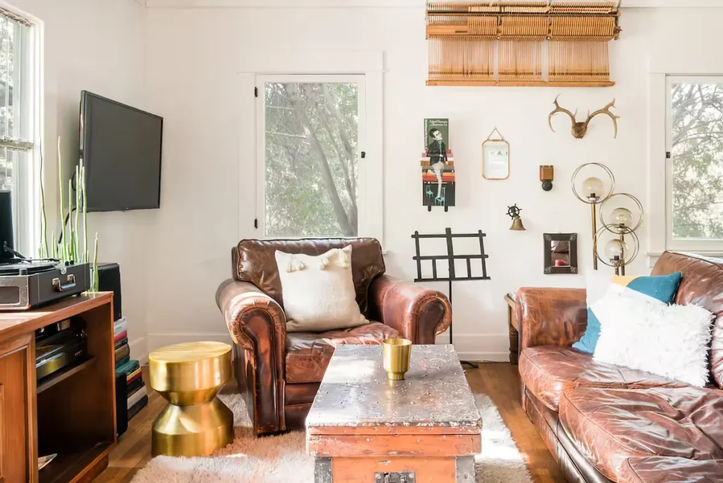 Cozy off-season vacation rental living room with vintage leather armchairs, rustic coffee table and soft natural light