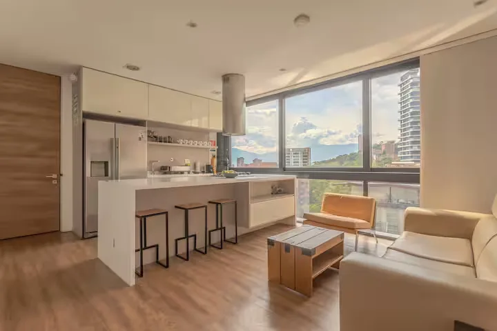 Empty modern vacation rental apartment with open kitchen, large windows and city views in quiet off-season