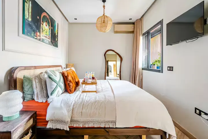 Cozy boutique hotel bedroom with crisp linens, decorative pillows and a bedside tray, perfect for a quiet off-season getaway.