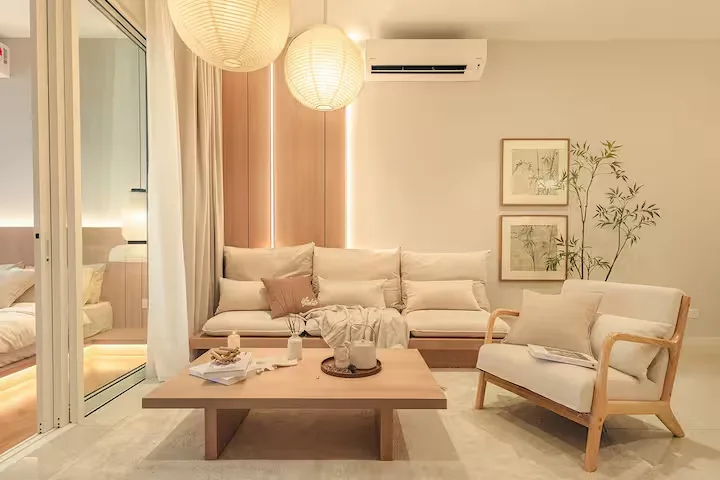 Cozy hotel suite living room with paper lanterns and warm wood accents, ideal for off-season travel relaxation.